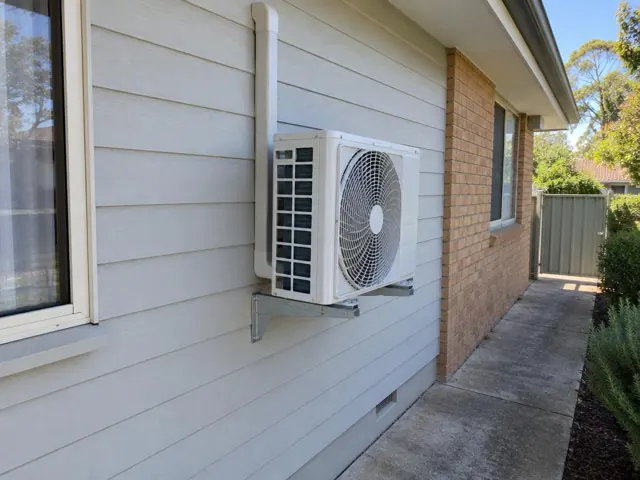 Wall-mounted air conditioner unit beside a brick-and-clad house exterior in Modbury